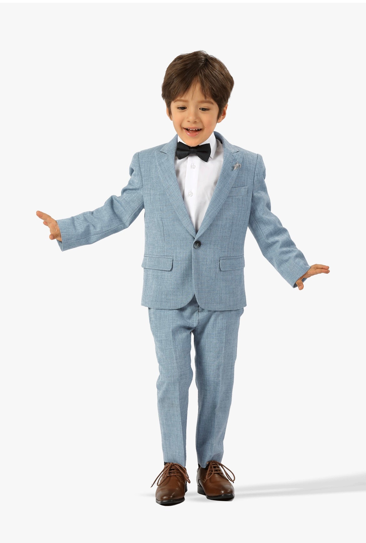 Young boy wearing a light blue suit with a white shirt and black bow tie on a white background