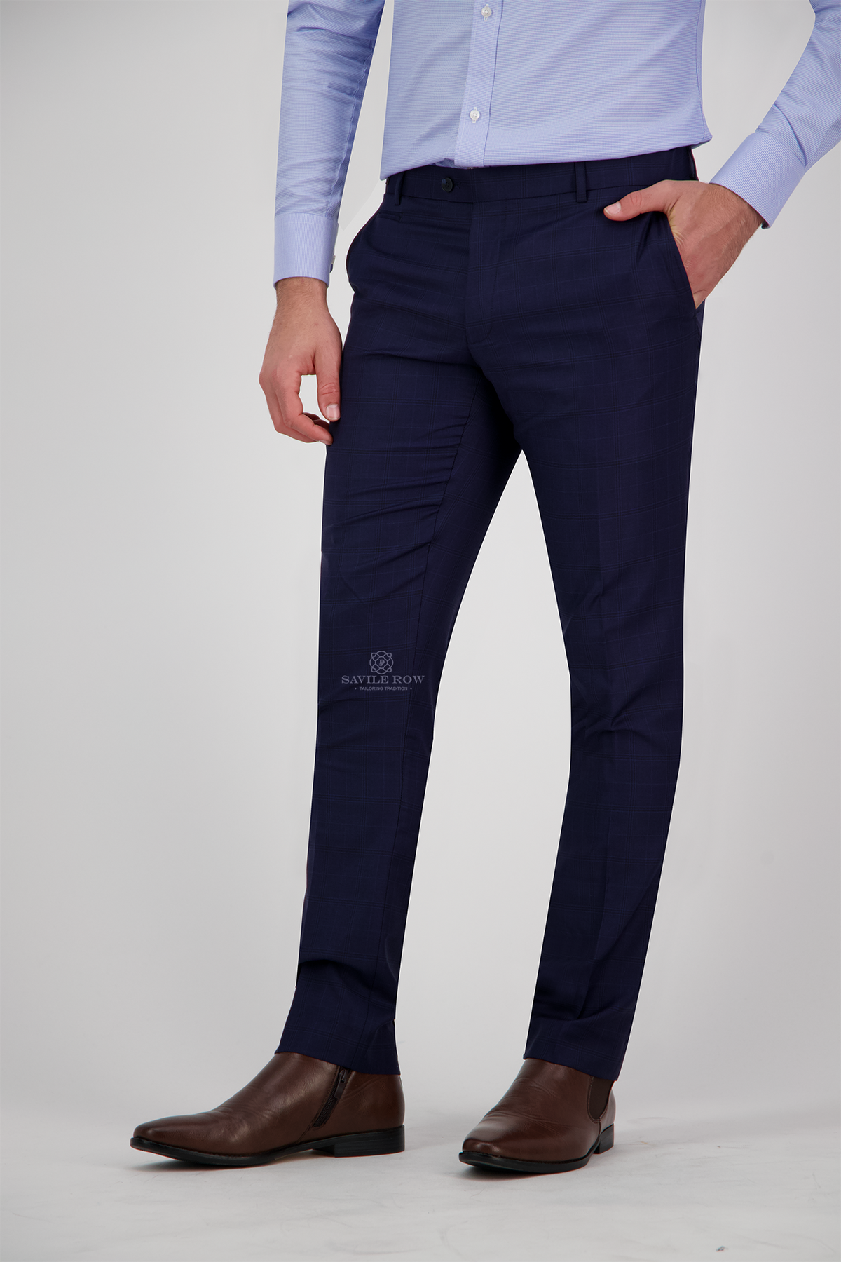 Navy blue dress pants worn with a light blue shirt and brown shoes on a white background.