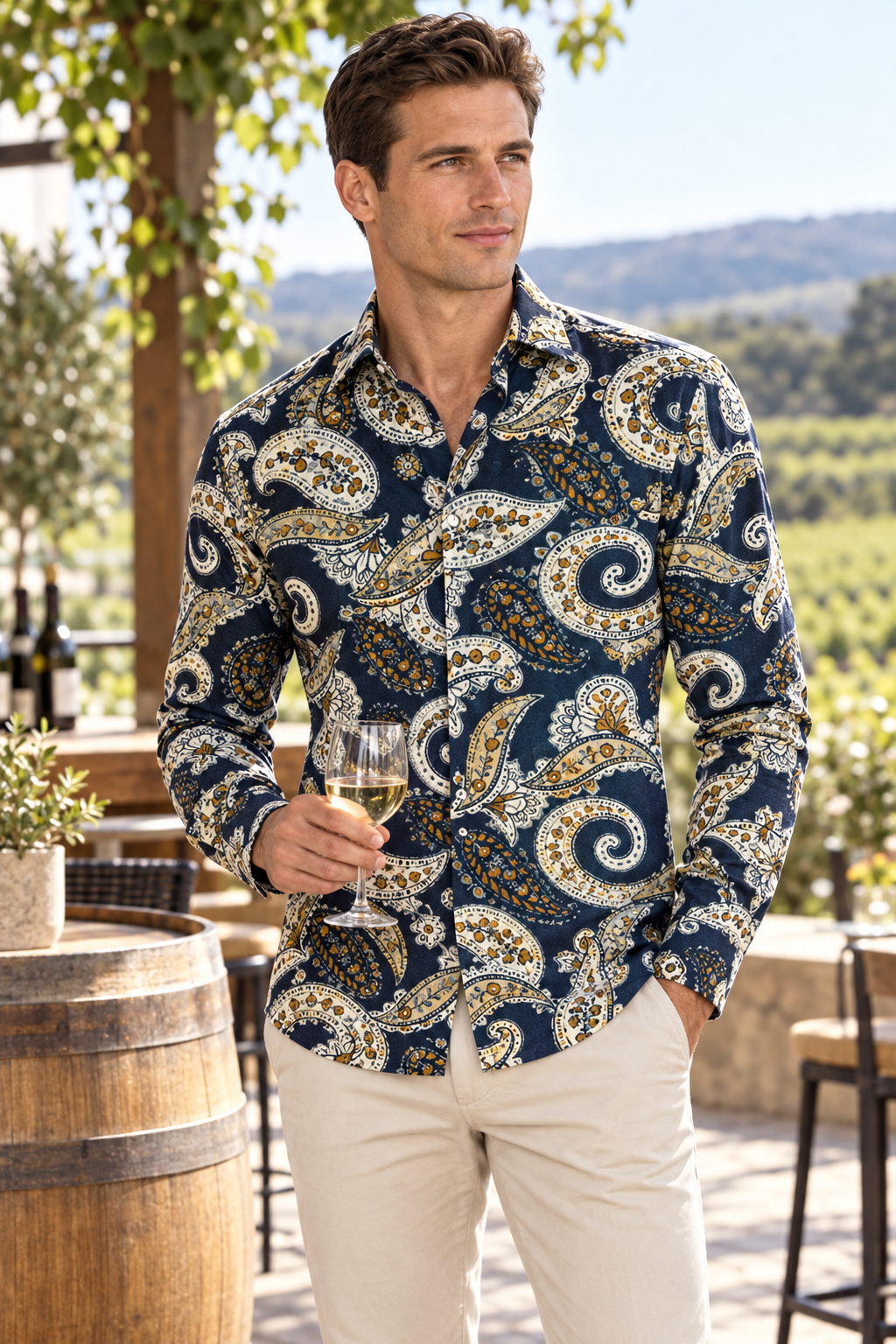 Model wearing Cambridge Sorrento FCW223 navy cream and gold paisley cotton shirt with stone trousers at an outdoor terrace